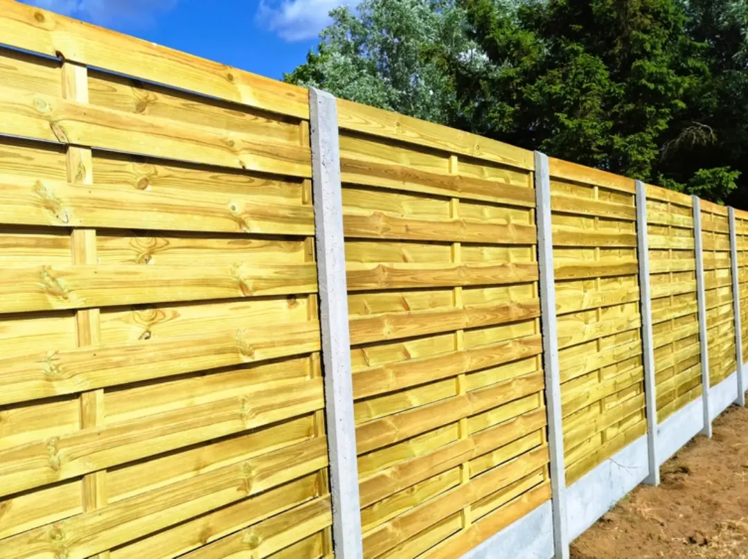 Modern horizontal wood plank fence and gates with a concrete base and metal posts.